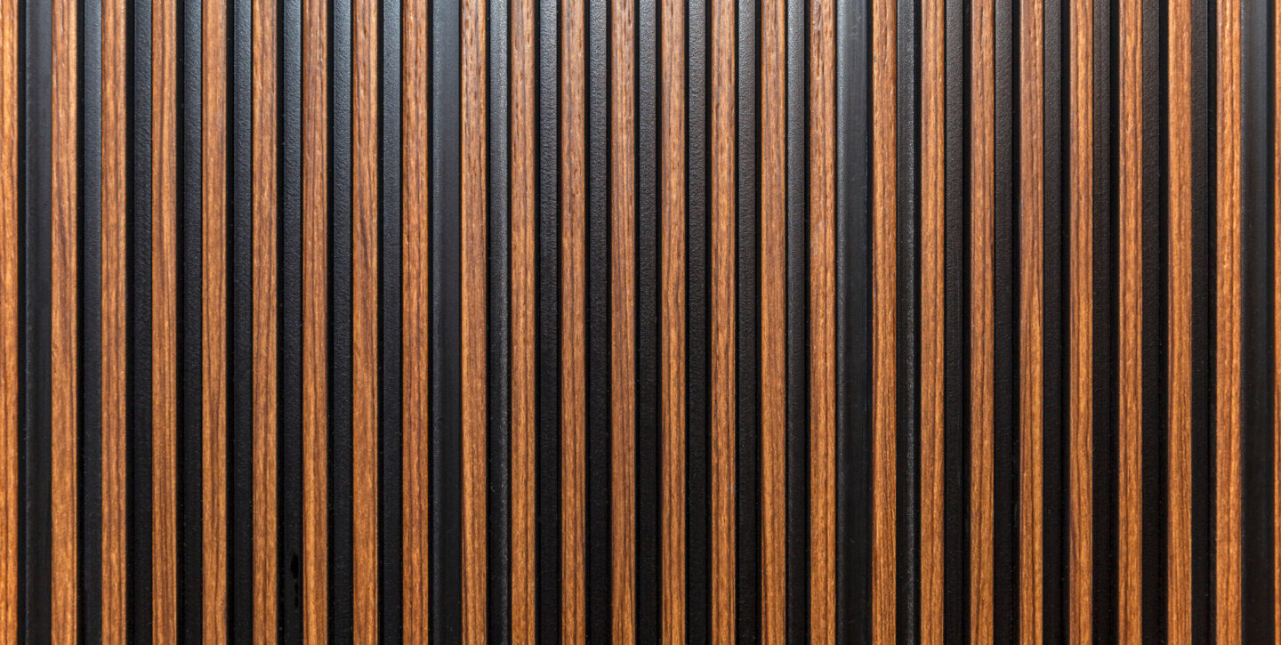 Close-up of vertical brown and black striped wall paneling with a textured surface.